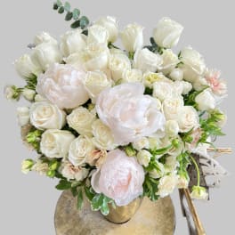 Cream and blush bouquet of roses and peonies in a gold vase