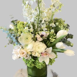 White floral arrangement in a green glass vase