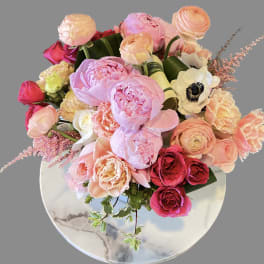 Bouquet of pink and peach flowers in a round vase