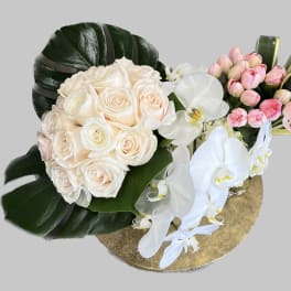 Bouquet of cream roses and white orchids with pink tulips on a gold base
