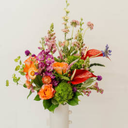 Colorful mixed bouquet in a tall white vase