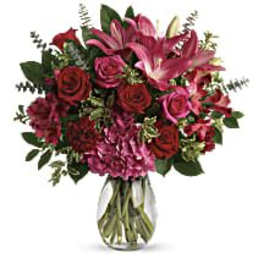 Bouquet of pink lilies, roses, and alstroemeria in a clear glass vase