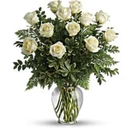 White roses arranged in a clear glass vase