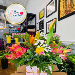 Mixed bouquet in a pink gift box with pink, yellow, and white flowers