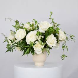 White rose arrangement in a cream vase