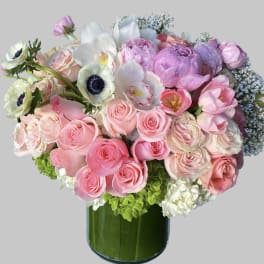 Pink and white mixed bouquet in a green glass vase