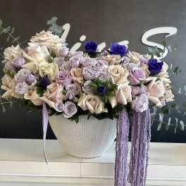 Lavender and cream rose arrangement in a white textured vase
