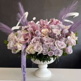 Lavender and blush rose arrangement in a white pedestal vase