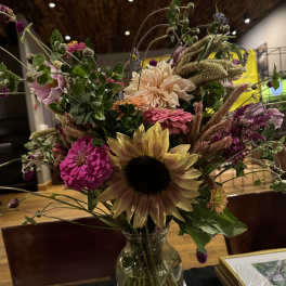 Mixed bouquet with a sunflower in a glass vase