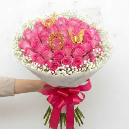Pink rose bouquet with baby’s breath, butterflies, and a ribbon bow