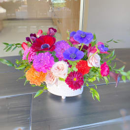 Colorful mixed flower arrangement in a white ceramic bowl