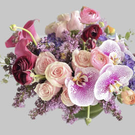 Bouquet of pink roses, orchids, calla lilies, and purple flowers