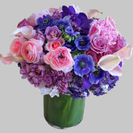 Pink and purple bouquet in a green glass vase