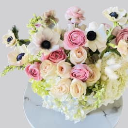 Bouquet of pink and cream flowers with white blooms in a round vase