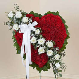 Heart-shaped red floral standing spray with white roses and a white ribbon