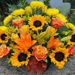 Sunflower and orange lily bouquet with peach roses in a vase