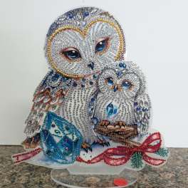 Jeweled owl and owlet figurine with blue gem cube and red beaded bow on a clear stand