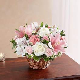 Pink and white mixed flower arrangement in a wicker basket
