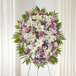 Standing floral wreath with white lilies, pink roses, and purple accents