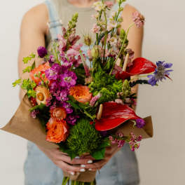 Handheld bouquet with bright mixed flowers and red anthuriums