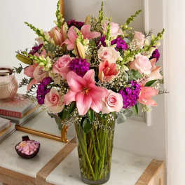 Pink lilies and roses in a clear glass vase