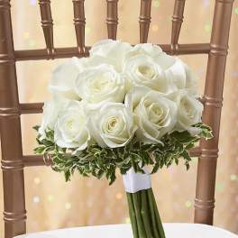 White rose bouquet with variegated greenery on a chair