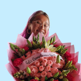 Woman holding a large bouquet of pink roses and lilies