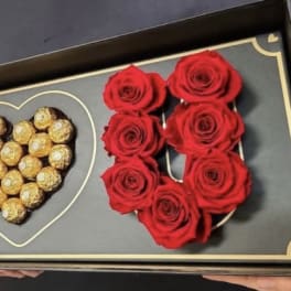 Boxed arrangement of red roses and Ferrero Rocher chocolates in heart shapes