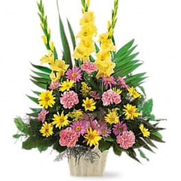 Tall floral arrangement with yellow gladiolus and pink daisies in a decorative vase