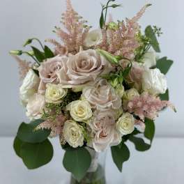 Bouquet of pale roses and pink astilbe in a glass vase