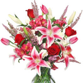 Bouquet of pink lilies and red roses in a glass vase