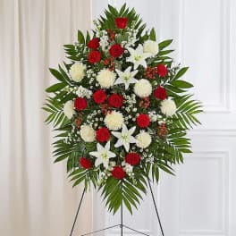 Standing floral spray with red roses, white lilies, and white pompons