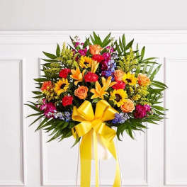 Colorful standing floral spray with a yellow ribbon bow