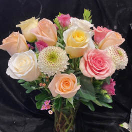 Bouquet of pastel roses and white chrysanthemums in a glass vase