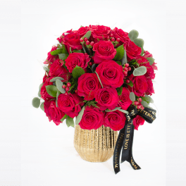 Bouquet of red roses in a gold vase with a black ribbon