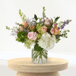 Bouquet of pink, peach, and white flowers in a clear glass vase