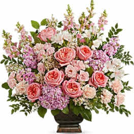 Pink roses and lilac flowers arranged in a dark vase