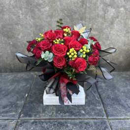 Bouquet of red roses with yellow berries and black ribbon wrapping
