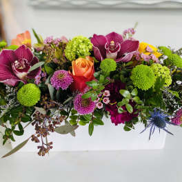 Colorful mixed bouquet with orchids, roses, and green pompon blooms