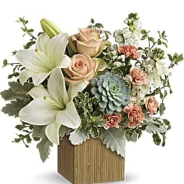 White lilies and peach roses in a wooden cube vase