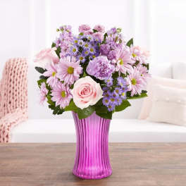 Pink and lavender bouquet in a purple glass vase