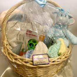 Gift basket with baby clothes, plush toys, and a teether