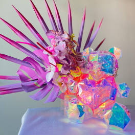 Purple floral arrangement with an iridescent crystal bear sculpture