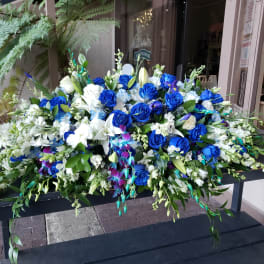Large blue and white floral arrangement with roses and lilies
