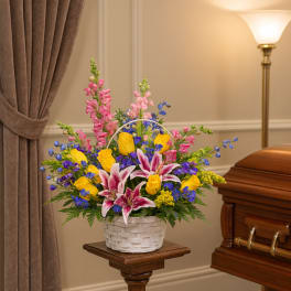Colorful funeral basket with lilies, roses, and snapdragons