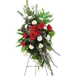 Standing floral spray with red roses and white carnations on an easel