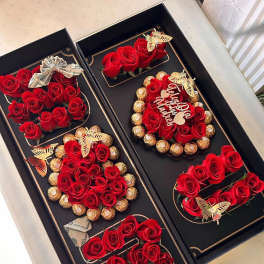 Black gift boxes with red roses, chocolates, and folded cash bows