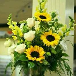 Sunflower and white rose arrangement in a clear glass vase