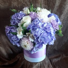 Lavender and white bouquet in a round pastel box