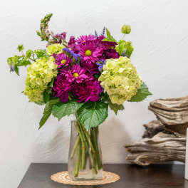 Magenta and lime hydrangea bouquet in a clear glass vase